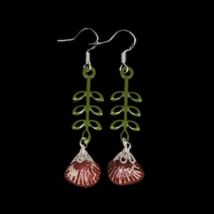 May include: A pair of dangle earrings with green leaf-shaped charms and red flower-shaped charms.