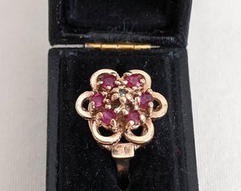 10k gold flower ring with 6 red (dark pink) spinels and 1 center diamond, comes with box, US size 6 1/4, 2.9 grams