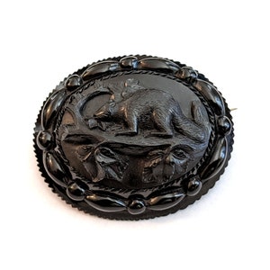 Victorian era black mourning brooch, center has a carved animal; 2 1/4 inches wide