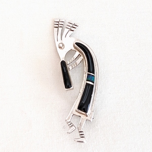 Robert Vandever de la nación Navajo, broche Kokopelli de plata esterlina con ónix y ópalo negro; 2 pulgadas de alto