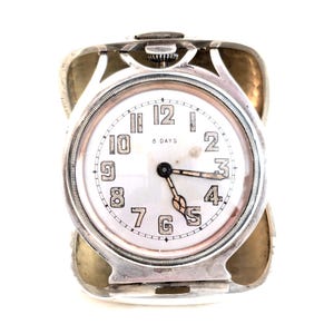 Reloj de viaje de 8 días, de estilo Art Decó, con mecanismo giratorio, caja y bisel en plata esterlina de R. Blackington, monograma "CMB"; 2 3/4 x 3 x 2 1/4 pulgadas abierto