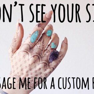 Puede incluir: Una mano con tatuajes de henna muestra varios anillos con piedras de turquesa y amatista. Los anillos tienen bandas color cobre. El texto en la parte superior dice "DON'T SEE YOUR SIZE?" y en la inferior "MESSAGE ME FOR A CUSTOM RING!"