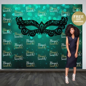 May include: A teal green backdrop with gold text that reads "Margie's Sweet 16!" repeated throughout the background. A large black lace masquerade mask is centered on the backdrop.