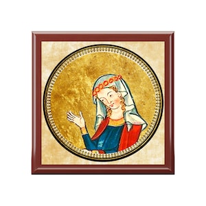 May include: A framed medieval illustration of a woman with a white veil and a red and gold crown. She wears a blue dress with red sleeves, set against a gold background within a decorative border and a dark brown frame.