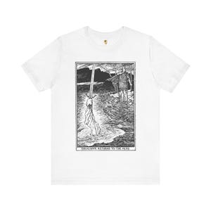 Könnte beinhalten: Weißes T-Shirt mit einer Schwarz-Weiß-Illustration einer Figur im Wasser, die ein Schwert hält, mit einem Ritter im Hintergrund. Der Text "EXCALIBVR RETURNS TO THE MERE" befindet sich am unteren Rand des Bildes.