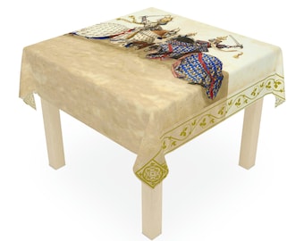May include: A square tablecloth with a medieval battle scene printed on it. The tablecloth is beige with a decorative green border. The illustration depicts knights in armor, with swords and shields. The tablecloth is on a light-colored wooden table.