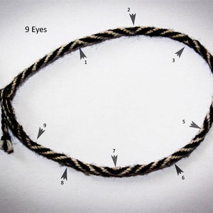 May include: A black and white braided rope with nine loops, labeled "9 Eyes" and numbered 1 through 9.