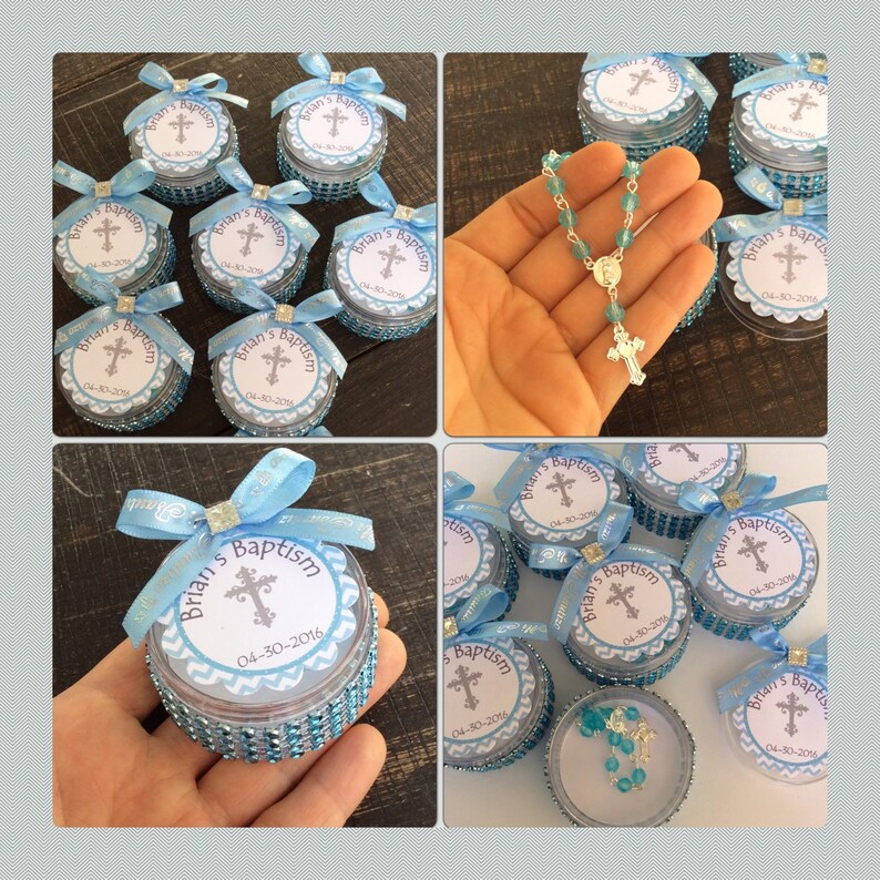 May include: A collection of baptism favors. Each favor is a small, round container with a blue ribbon and a label that reads "Brian's Baptism" with a cross and the date 04-30-2016. A rosary is also shown.