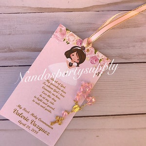 May include: Pink and gold First Holy Communion favor with a pink rosary, a floral design, and the text "My First Holy Communion Valerie Vazquez April 28, 2018".