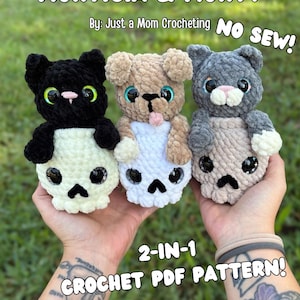 May include: Three plush crochet toys featuring animals sitting on skulls. The left is black, the center is tan with a tongue out, and the right is gray. Text reads: MORTICIA & MORTY, By: Just a Mom Crocheting, NO SEW!, 2-IN-1 CROCHET PDF PATTERN!