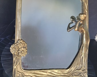 Art Nouveau mirror showing a beautiful maiden standing at a flowering tree admiring her reflection