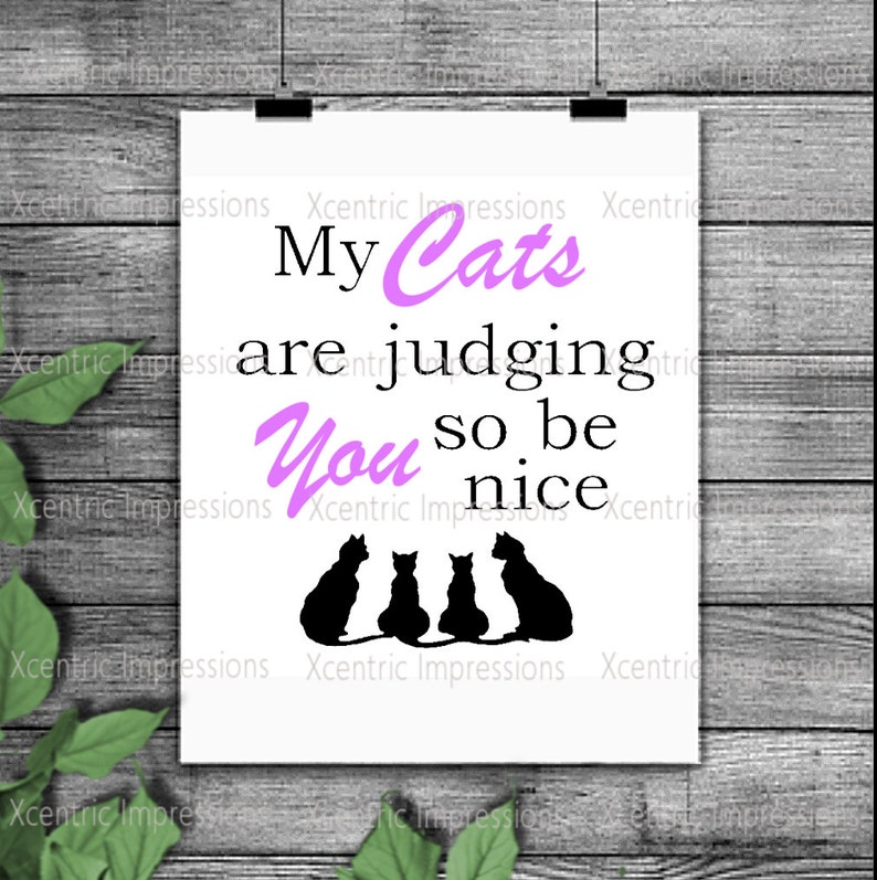 May include: A white printable sign with black silhouettes of three cats sitting in a row. The text on the sign reads "My Cats are judging you so be nice".
