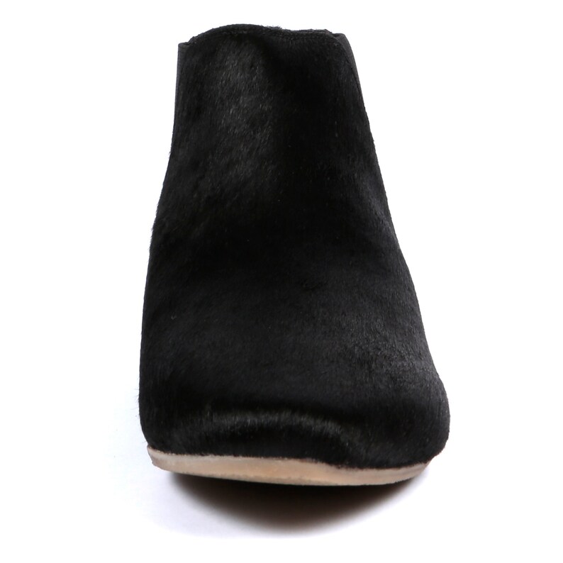 May include: A black ankle boot with a textured, fur-like appearance. The boot has a rounded toe and a low, neutral-colored sole. The footwear is set against a white background.