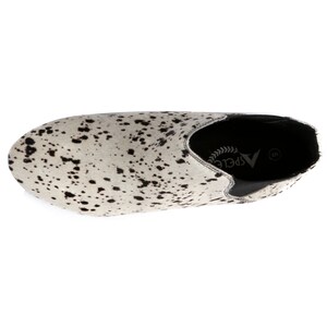 May include: A single shoe with a cowhide pattern. The shoe is white with black spots, and has a black elastic side panel. The brand name "ASPELE" is visible on the insole.