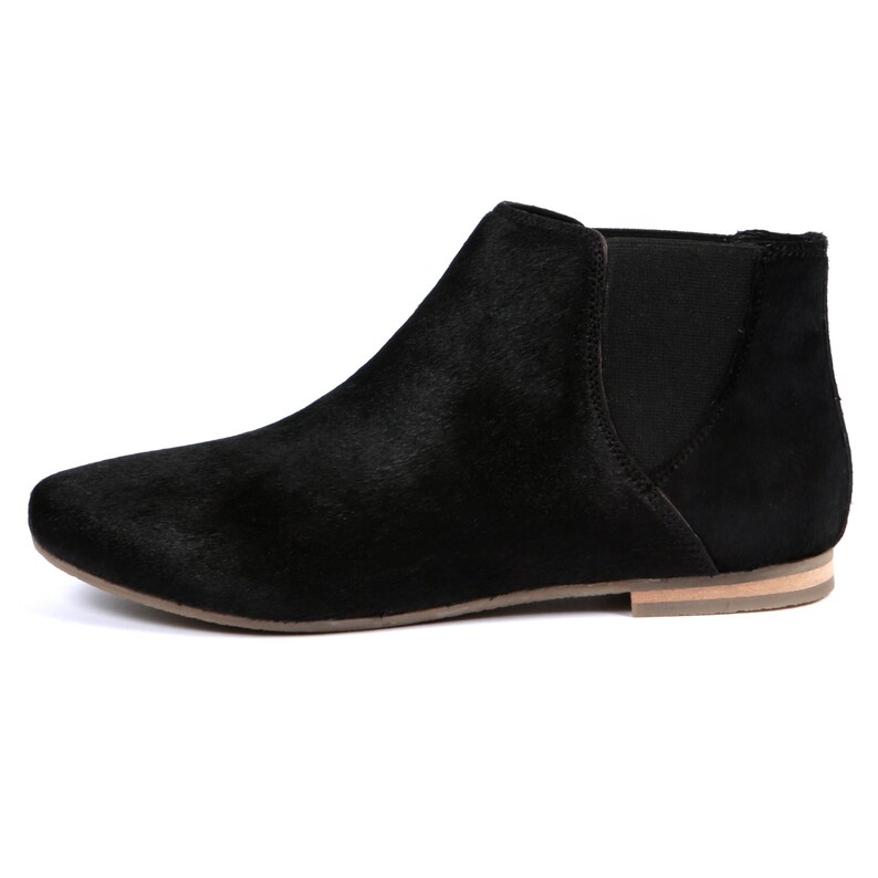 May include: Black ankle boot with a pointed toe and elastic side panel. The boot has a low heel and a textured upper. The sole is a light tan color. The boot is a slip-on style.