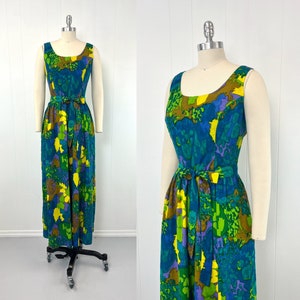 May include: A sleeveless maxi dress with a vibrant abstract print in shades of blue, green, yellow, and purple. The dress has a fitted bodice and a flowing skirt with a self-tie belt.