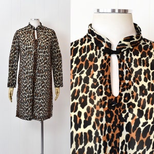 May include: A long-sleeved, brown, black, and white leopard print dress with a mandarin collar and a keyhole opening at the neckline.