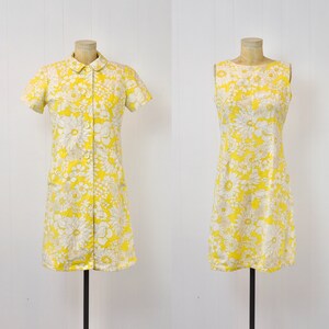 May include: Two yellow dresses with white floral patterns. One dress has short sleeves and a button-up front, while the other is sleeveless.