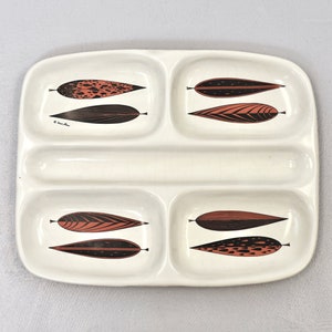 May include: A white ceramic divided serving dish with four sections. Each section features a stylized black and red leaf design.