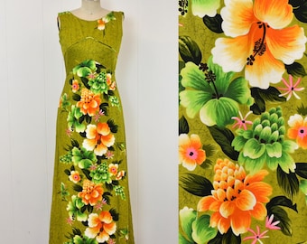 Könnte beinhalten: Ein ärmelloses, bodenlanges Kleid in Olivgrün mit einem lebendigen Blumenmuster aus großen orangefarbenen und weißen Hibiskusblüten, kleineren grünen Blüten und dunkelgrünen Blättern. Das Oberteil ist körpernah geschnitten und hat einen Rundhalsausschnitt.