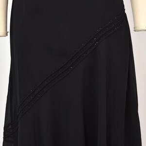 May include: A black formal dress with a flowing skirt. The dress has a diagonal beaded design across the front. The dress is displayed on a mannequin, showcasing its elegant drape and design. Suitable for special occasions.