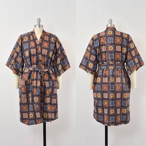 May include: A blue and orange patterned robe with a sash tie. The robe has a short sleeve and a collar.