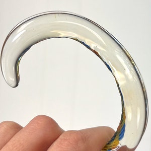 May include: A clear glass cane handle with a swirl pattern in shades of blue, yellow, and orange.