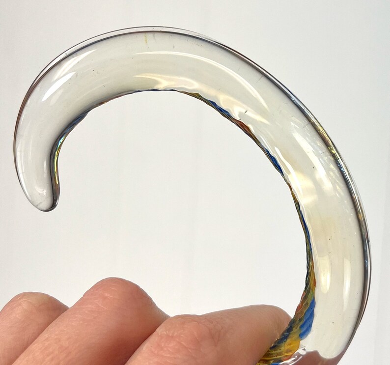 May include: A clear glass cane handle with a swirl pattern in shades of blue, yellow, and orange.