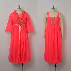 May include: A vintage neon pink lingerie set, including a long-sleeved robe with a matching belt and a sleeveless nightgown. The robe features lace trim and a ruffled collar. The nightgown has a square neckline with lace detailing.