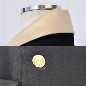 May include: A black blazer with a large gold button and a beige collar.