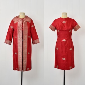 May include: A red brocade dress and matching jacket with gold embroidery. The dress has a fitted bodice and a straight skirt. The jacket has a collar and long sleeves.