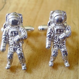 Un paio di grandi gemelli in argento sterling raffiguranti astronauti in una scatola regalo