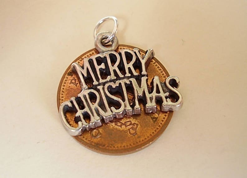 May include: Silver charm with the words "Merry Christmas" on a copper penny.