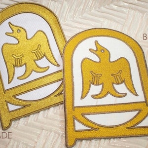 May include: Two embroidered patches with a gold eagle design on a white background. The patches are labeled "A GRADE" and "B GRADE".