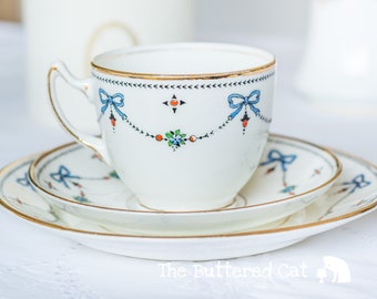 Charming antique art deco English china tea trio, hand-decorated blue ribbon bows, swags