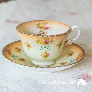 Antique Royal Albert Crown China cup and saucer, hand-enamelled turquoise blue ribbon bows