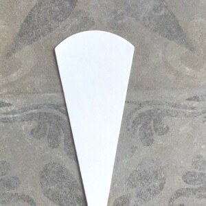 May include: A white paper cone, often used for holding flower petals or confetti at weddings or other celebrations.