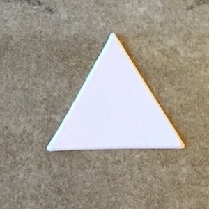 May include: A white triangle-shaped tile with a smooth surface.