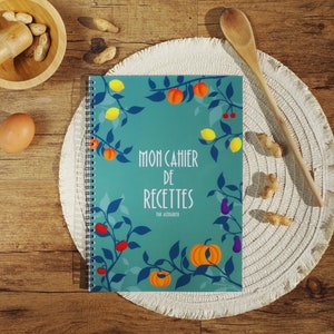 K&ouml;nnte beinhalten: Ein t&uuml;rkisfarbenes Notizbuch mit Spiralbindung, einem farbenfrohen Blumendesign und dem Text "Mon Cahier de Recettes par Alezandra".
