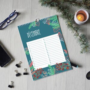 May include: A wall calendar with a teal background featuring a botanical pattern of green pine needles and red berries. The page is titled D&Eacute;CEMBRE and contains a white rectangular grid with numbered lines from 1 to 31 for daily planning.