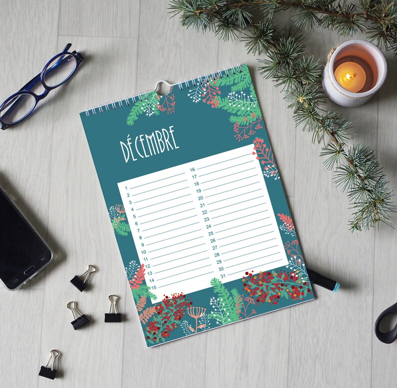 May include: A wall calendar with a teal background featuring a botanical pattern of green pine needles and red berries. The page is titled D&Eacute;CEMBRE and contains a white rectangular grid with numbered lines from 1 to 31 for daily planning.