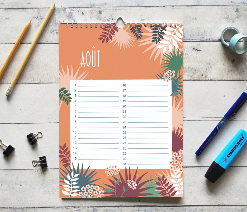 May include: A wall calendar page for the month of August, labeled with the text AO&Ucirc;T, featuring a peach-colored background decorated with botanical illustrations of leaves and flowers in shades of green, white, and dark purple, with a white grid.