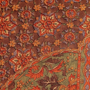 May include: A textile fabric featuring a brown background with a repeating pattern of orange, yellow, and purple floral star motifs. A curved section displays a green field filled with orange leaves, small flowers, and berries, bordered by orange.