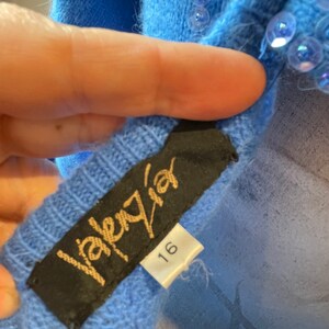 May include: A blue sweater with sequins and a black label that says "Valery" and "16".