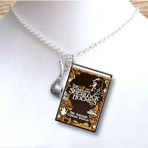 May include: A silver chain necklace with a charm of a book titled "The Complete Sherlock Holmes" by Sir Arthur Conan Doyle and a silver pipe charm.