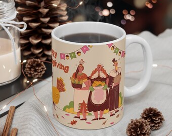 Può includere: Una tazza in ceramica bianca con sfondo beige e un design a tema del Ringraziamento. Il design presenta tre persone che tengono cesti di cibo e un tacchino. Il testo "Happy Giving" è stampato sulla tazza.