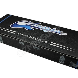 May include: Black cardboard box with a blue and white logo that says "miniquitar collect them all" and the words "MINIATURE GUITAR" printed on the front.
