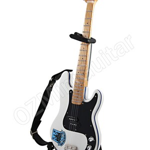 May include: White electric guitar with a black pickguard, blue trim, and a wooden neck. The guitar has a black strap and is displayed on a black stand. A logo is visible on the body.