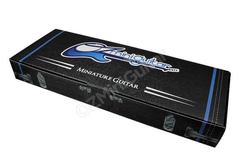May include: Black miniature guitar case with the text "miniGuitar" in a blue and white design. The case has a textured surface, white stripes, and blue trim. The case also has silver-colored latches.