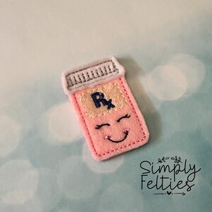 May include: Pink felt pill bottle with a smiling face and the letters "Rx" on the label.